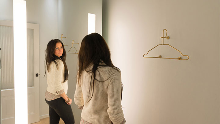 Une cliente de SuperTrash se regarde dans le miroir AmbiScene avec le paramètre de lumière « Jour »