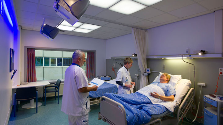 Docteurs au chevet d'un patient dans une chambre équipée du système Philips HealWell