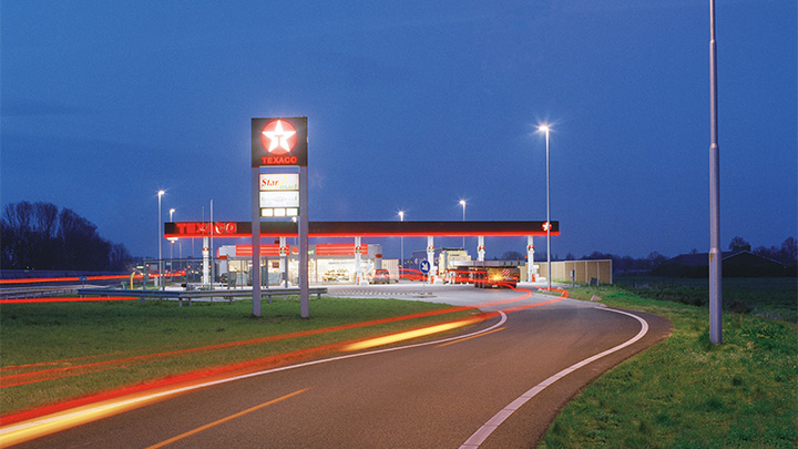 Een Texaco tankstation naast de snelweg, aantrekkelijk verlicht in de schemering: in het oog springende buitenverlichting