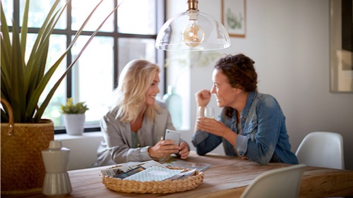 Deux femmes à la maison parlent sous une ampoule Philips