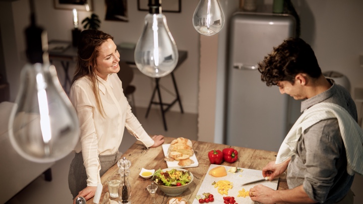 Vue de dessus d'un homme et d'une femme préparant le dîner dans une cuisine bien éclairée