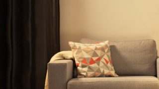 "Gezellige woonkamer met moderne LED tafellamp, die grijze loveseat verlicht en een warme sfeer creëert voor ontspanning thuis."