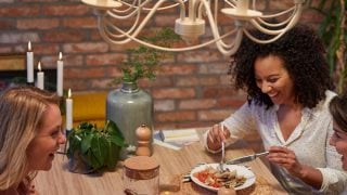 "Moderne keuken met vintage stijl LED-hanglampen die de twee vrouwen die aan het dineren zijn verlichten, en zo een warme, uitnodigende sfeer creëren."