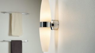 "Moderne badkamer met slanke LED wandlamp, die de minimalistische inrichting verlicht en de spa-achtige sfeer versterkt."