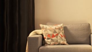 Gezellige woonkamer met moderne LED tafellamp, die een grijze loveseat verlicht en een warme sfeer creëert voor ontspanning.