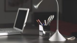 une lampe de bureau et un ordinateur portable posés sur un bureau