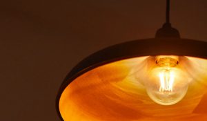 "Ampoule à filament LED de style vintage dans une lampe suspendue, émettant une lueur dorée chaude, présentant un éclairage nostalgique économe en énergie pour une ambiance de la maison chaleureuse."